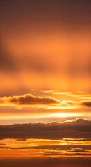 Fototapeta premium Vibrant orange sky with dramatic clouds illuminated by golden sunlight during sunset or sunrise
