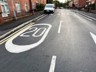 Obraz premium Quiet residential street in Manchester showing speed sign and parked vehicles