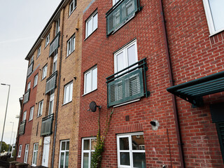 Brick residential complex in Manchester with outdoor balconies and road view