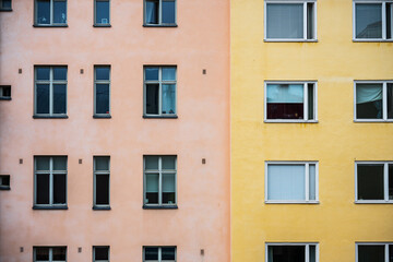 Fototapeta premium Pastel pink and yellow apartment building facade.
