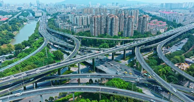 Aerial shot of a complex highway overpass interchange with traffic in a modern green city in Nanjing.