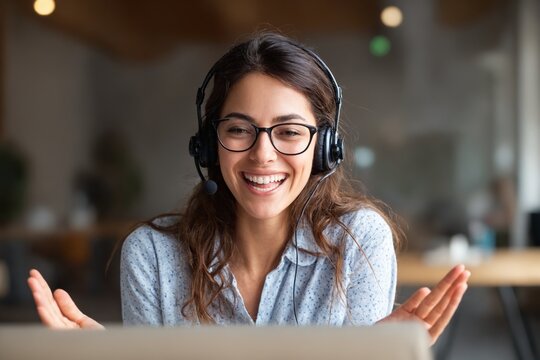Smiling woman in headset talking online — remote customer support or tutoring