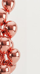 Pink metallic balloons cluster on a white background with copy space