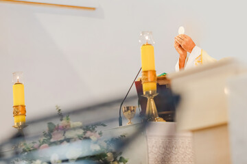 Catholic priest celebrating Holy Mass during liturgy with chalice, Bible, and liturgical vestments inside church, Eucharist and communion ceremony in Christian tradition