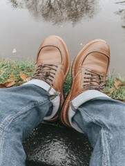 first-person view of casual shoes and puddle reflection