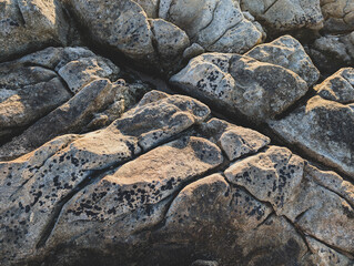 Close up of textured stone surface with cracks and natural colors