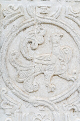 A white old wall with barillefs of stucco. Stone Texture Background with Patterns and Barillefs