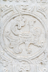 A white old wall with barillefs of stucco. Stone Texture Background with Patterns and Barillefs