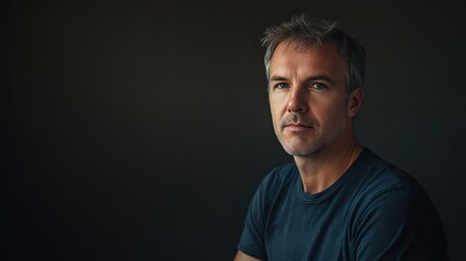 Naklejka premium Thoughtful Portrait of a Mature Man Against a Dark Background