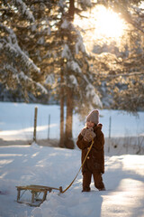 girl with sled in winter wearing a fur coat