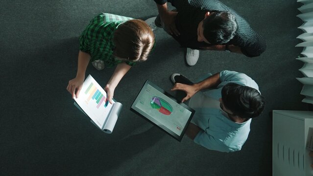 Caucasian businesswoman present and explain marketing strategy to investor while standing at meeting room. Leader looking at stock market chart and data analysis while making decision. Convocation.