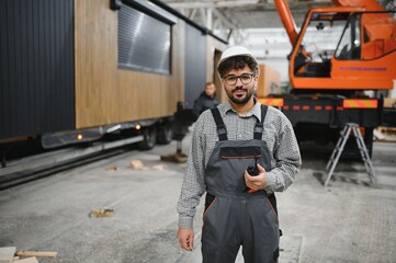 Arab engineer supervising prefabricated modular house production in construction workshop