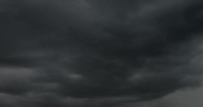 Black clouds are flying across the sky. A hurricane and bad weather are approaching.