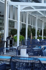 Modern outdoor café wall with vertical wooden slats and minimalist furniture. Perfect professional background for architecture, business, and design-related materials. Clean composition emphasizing 