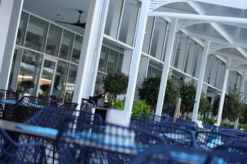 Outdoor hotel café with wooden wall panels, cozy dining tables, and modern design. Perfect visual...