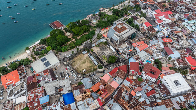 Aerial city view of area around Forodhani park, "House of Wonders" and "Old Ford" in historic Stone Town, the oldest part of Zanzibar Town on Unjuja island, Tanzania with beach along coastline