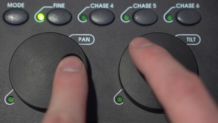 Close-up of hands adjusting Pan and Tilt shuttle controls on lighting console