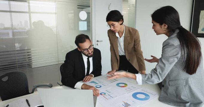 Group of three young managers analyzing company product