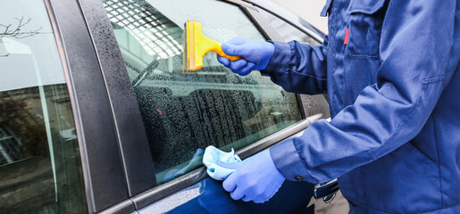 Male worker tinting car window