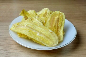 Thinly sliced raw bananas are deep-fried to a perfect crisp and lightly coated with a sweet and salty sugar glaze for a delicious snack.