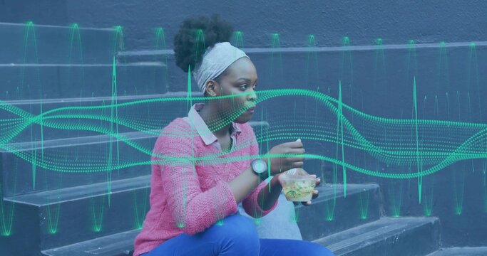 Woman wearing pink sweater eating salad in clear container on outdoor steps, with waveform overlay - Powered by Adobe