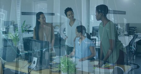 Collaborating professionals analyzing translucent data graphs in office, with monitors and papers