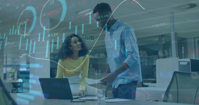 Reviewing financial charts and collaborating on data overlays in open office with laptop on desk