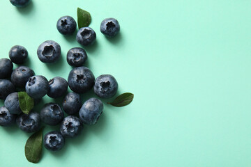 Heap of fresh ripe blueberry on turquoise background, closeup
