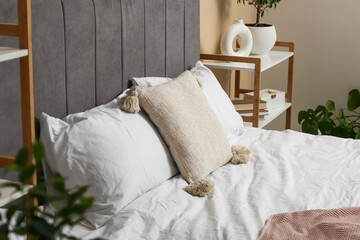 Big bed with soft pillows in stylish bedroom