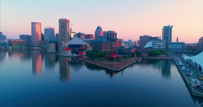 Aerial view of Baltimore's Inner Harbor at sunrise, Maryland, USA. The photo showcases the city's skyline, waterfront attractions, and urban landscape.