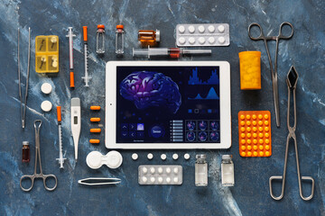 Fototapeta premium Tablet computer and medical supplies on grunge background. Telemedicine concept