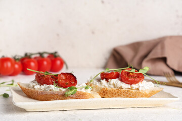 Plate of tasty tomato bruschetta with ricotta on white background