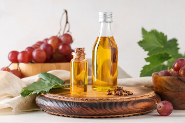 Bottles of cosmetic grape seed oil on white background