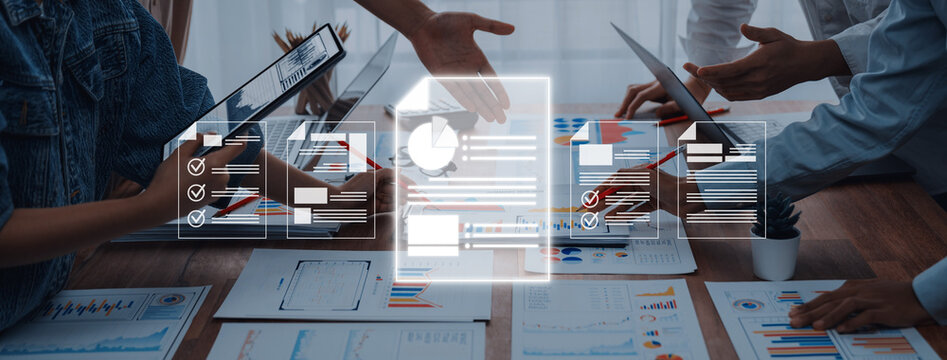 A modern business meeting scene illustrating collaboration with digital tools, featuring hands discussing various documents and analytics on devices in a professional office environment. Trope - Powered by Adobe