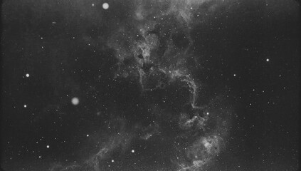 A monochrome celestial landscape displays a nebula, intricate and vast, with numerous scattered stars in a deep space environment.