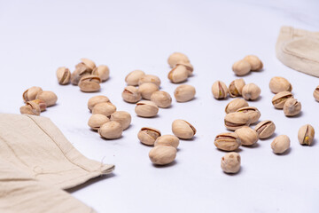 Several pistachio nuts in their shells on a light-colored countertop.