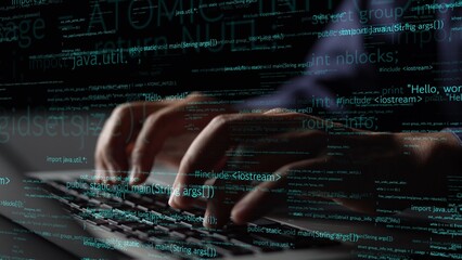A close-up view of hands typing on a laptop keyboard, illuminated by abstract programming code....