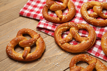 Napkin and tasty pretzels on wooden background, closeup