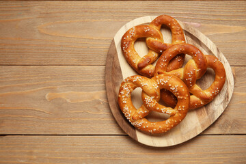 Tray with tasty pretzels on wooden background, closeup