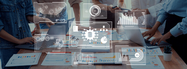 A collaborative team engages in a strategic meeting, utilizing technology and data visuals to analyze insights and enhance project outcomes in a modern office environment. Trope