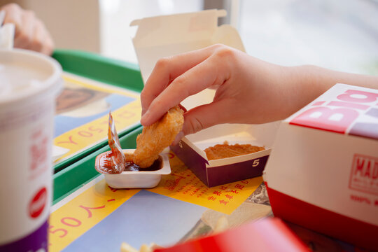 Girl eating chicken nuggets at McDonald's. マクドナルドでチキンナゲットを食べる女の子