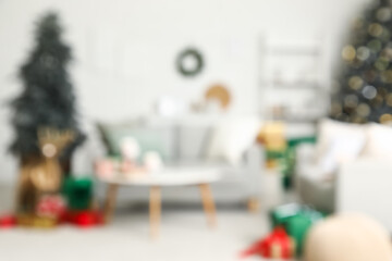 Blurred view of living room with sofas, Christmas trees and presents
