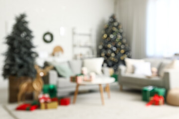 Blurred view of living room with sofas, Christmas trees and presents