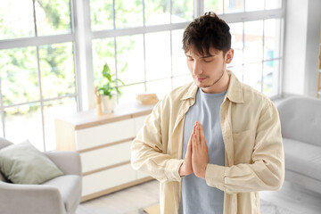 Handsome young man meditating at home