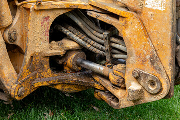 Backhoe with leaking swing cylinder. Heavy equipment maintenance, construction equipment repair and service concept.