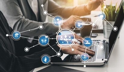 Business professionals collaborate at a modern workspace, utilizing a laptop with visual network icons that symbolize effective communication and technological innovation. Tessel