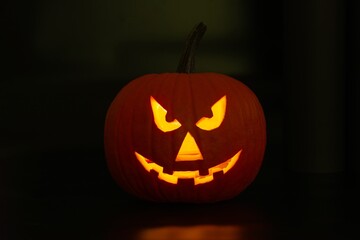 Scary jack o'lantern pumpkin in darkness. Halloween decor