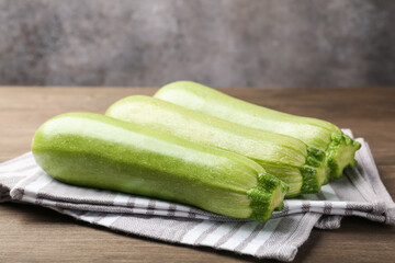 Fresh ripe zucchinis on wooden table, closeup