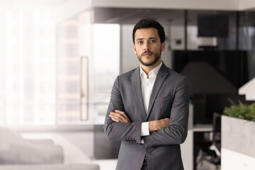 Serious young Middle Eastern business executive man posing in office