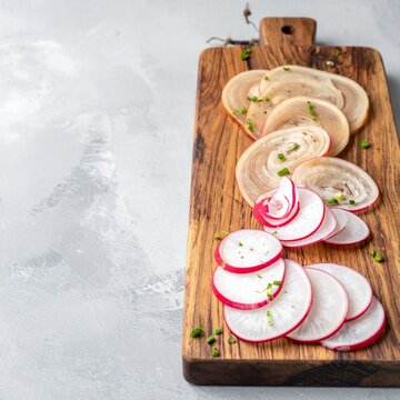 Rustikales Holzbrett mit Radi (Bierrettich in Spiralen geschnitten)